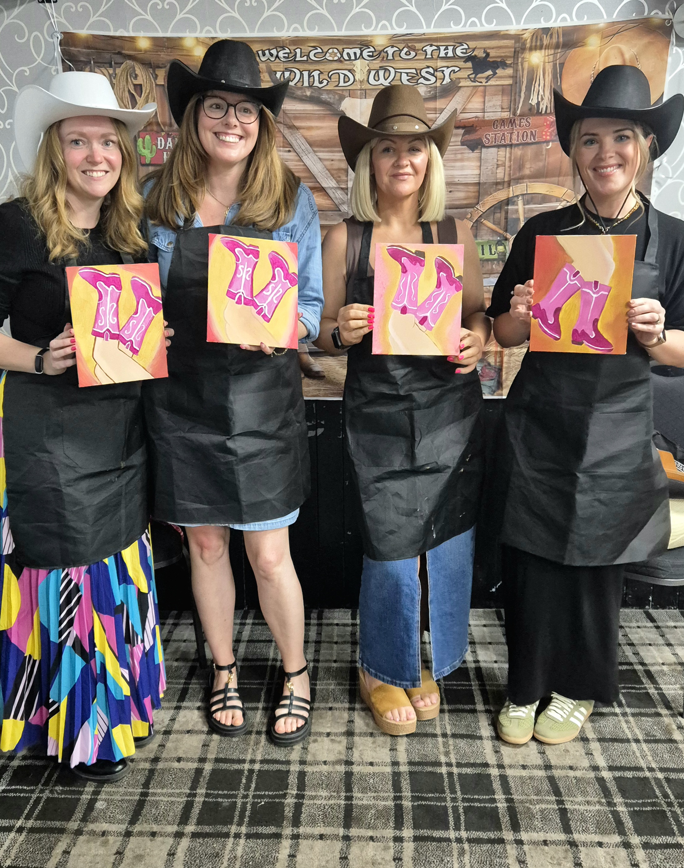 Photo of a group of people wearing cowboy hats holding their wild-west themed pictures.